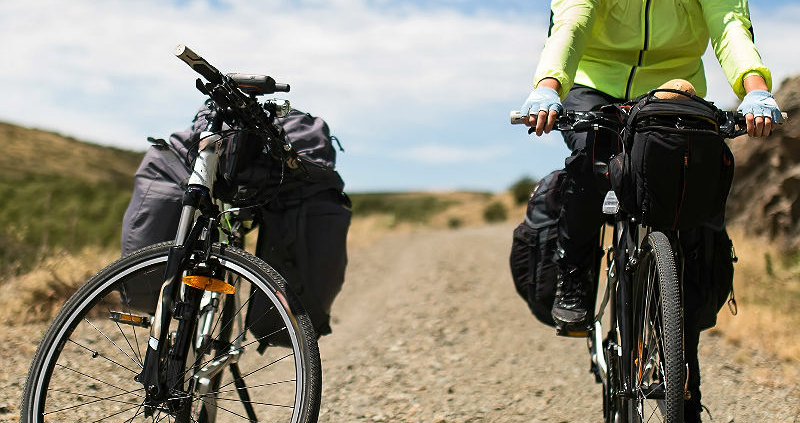 To sykler, en syklist i fjellandskap.