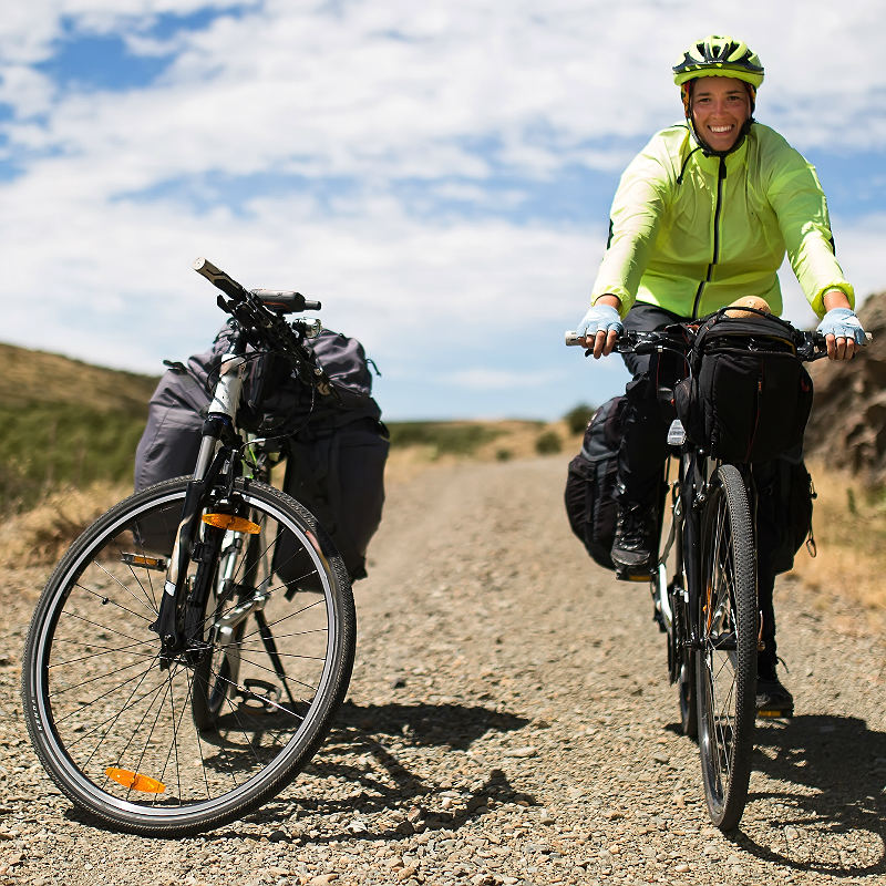 To sykler, en syklist i fjellandskap. Fint å være kjærester på sykkeltur. 