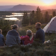 Familie i solnedgang i fjellandskap.